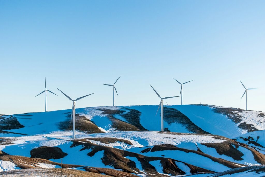 windmills surrounded by snow-covered field during daytime