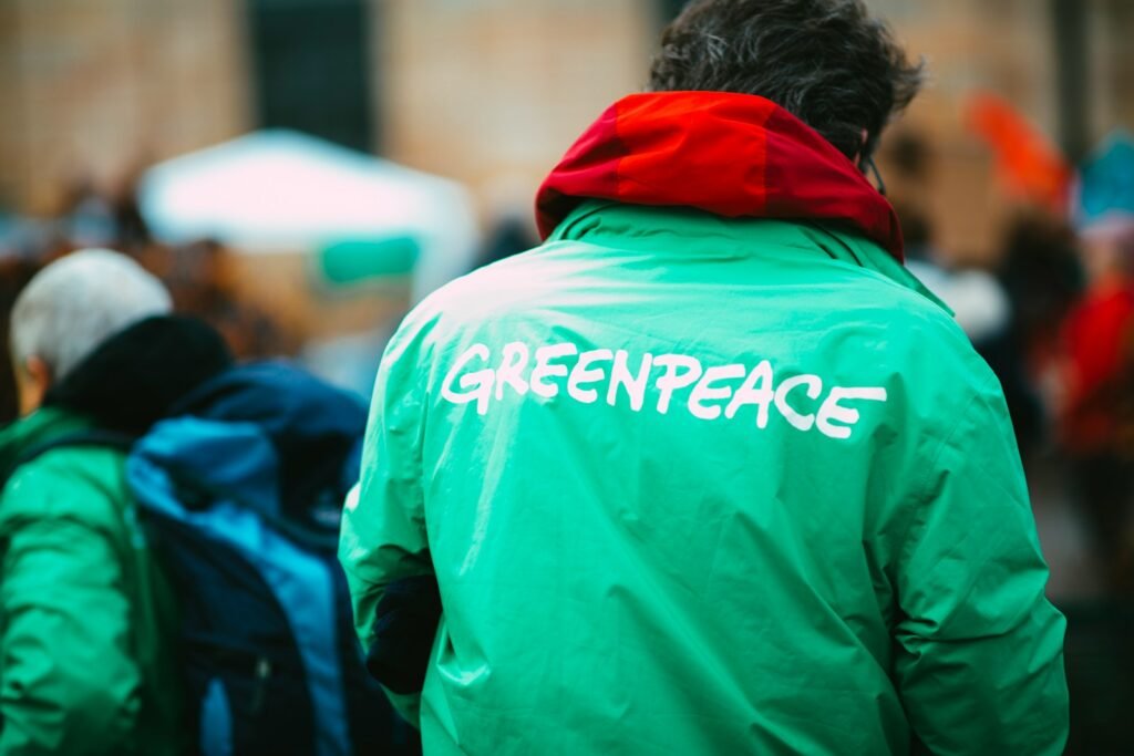 man in green hoodie walking on street during daytime