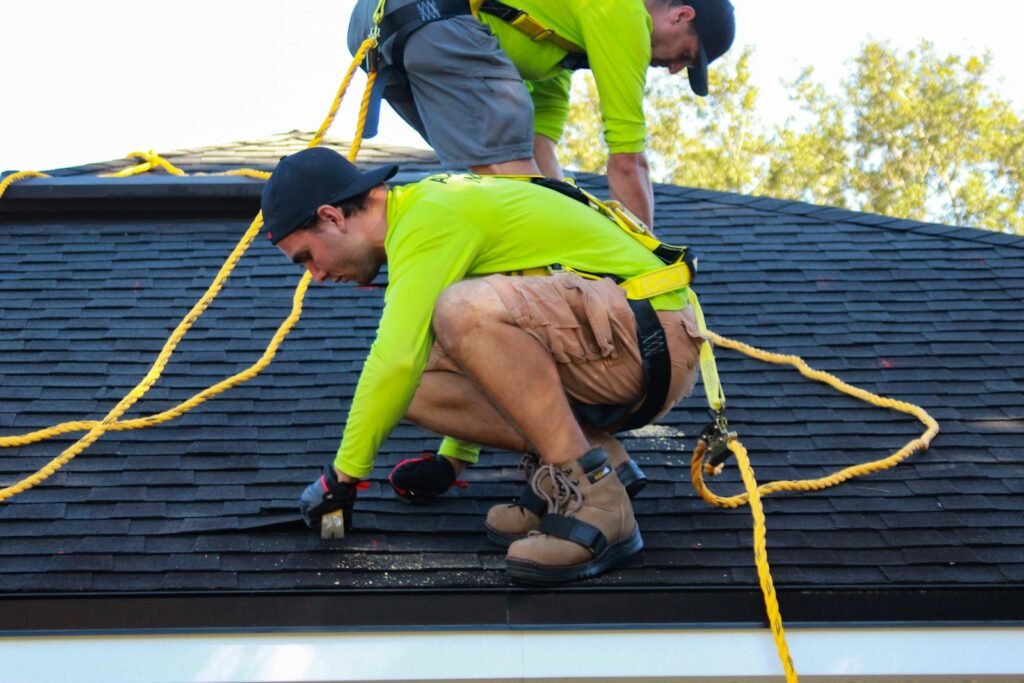 two men working on the roof of a house