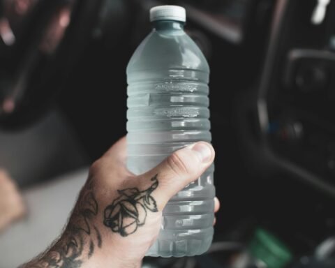 person holding clear plastic bottle