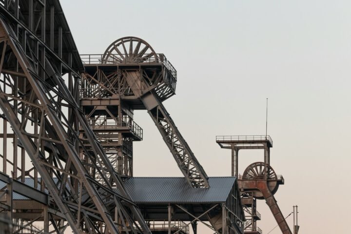 a very tall metal structure with a clock on it's side