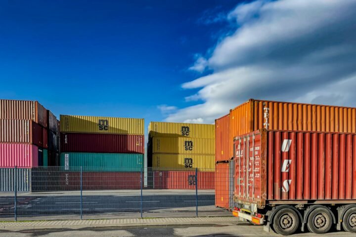 a truck is parked in front of a bunch of shipping containers