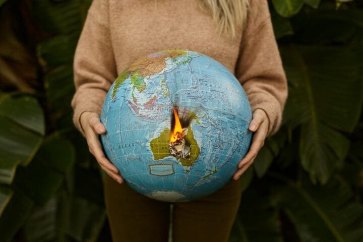 A woman holding a burning globe depicting Australia's climate crisis.